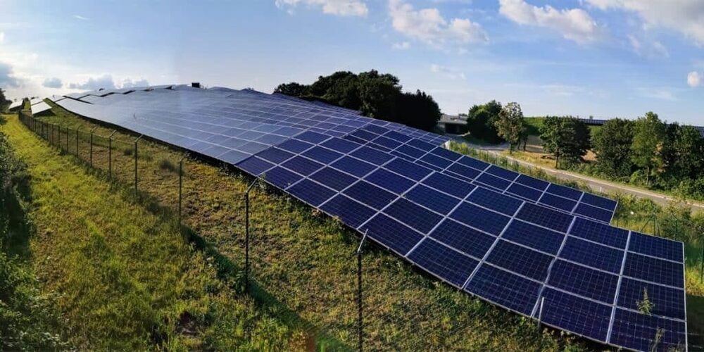 Windräder und Solarmodule in einer grünen Landschaft